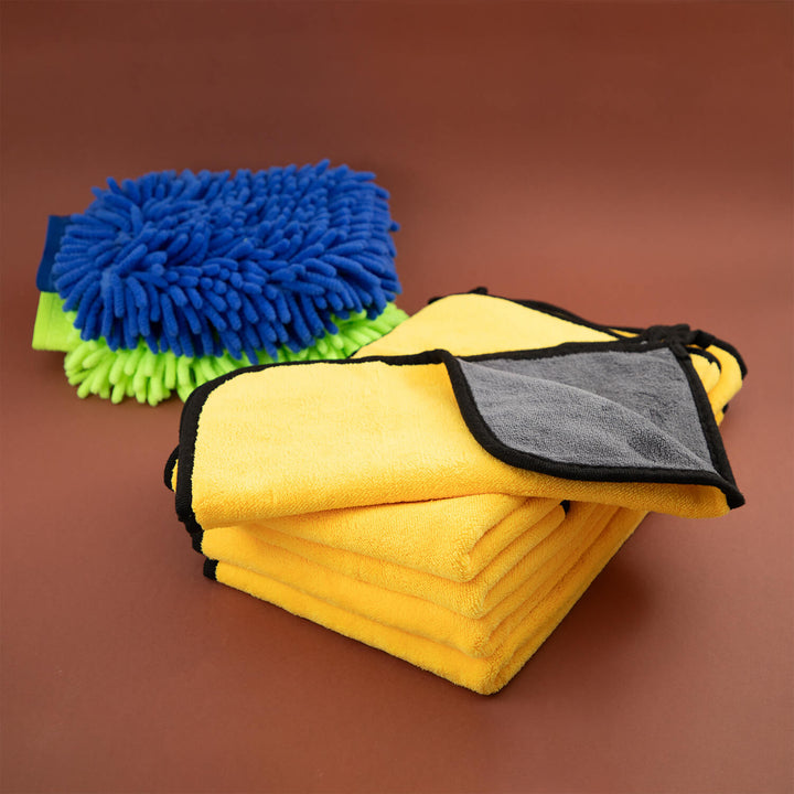 Yellow microfiber cloth, microfibre cleaning cloths, cleaning supplies, cleaning cloths with gray corner and blue and green scrubber on a brown background