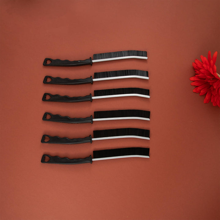 Set of black and white crevice cleaning tools, cleaning brush, cleaning supplies, microfibre on a brown background with a red flower.