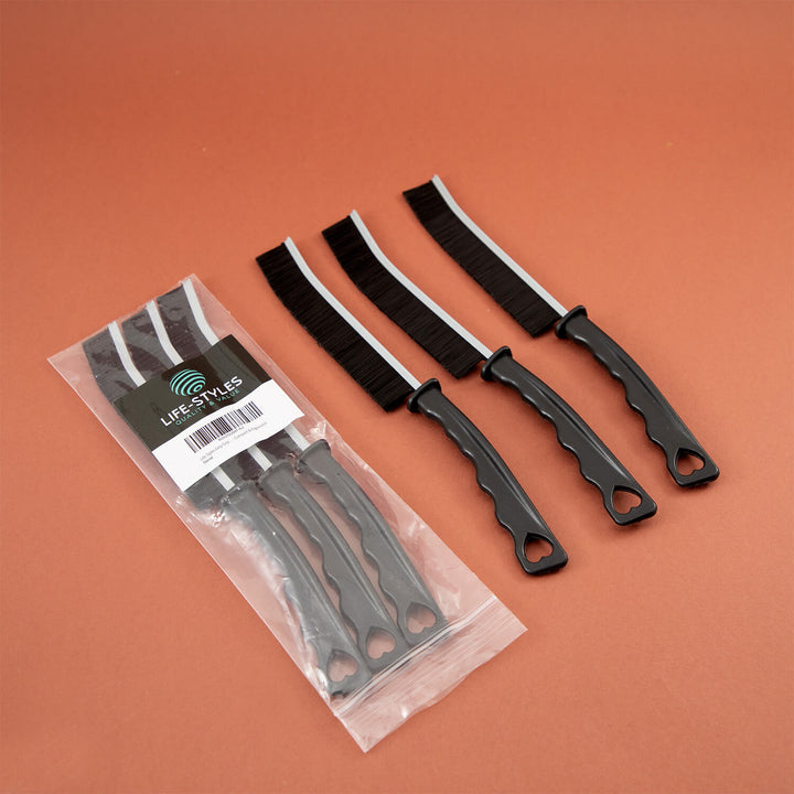 Set of black metal crevice cleaning tools, cleaning supplies, microfibre, with a clear plastic packaging on an orange background
