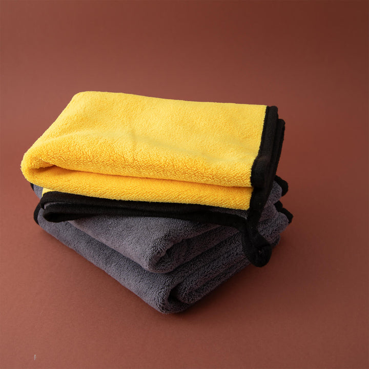 Stack of yellow and gray microfibre cleaning cloths, cleaning cloths, microfibre, cleaning supplies on a brown background